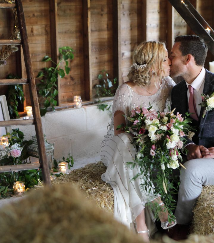 Kelly and Tom sat on hay bales for their small rustic wedding
