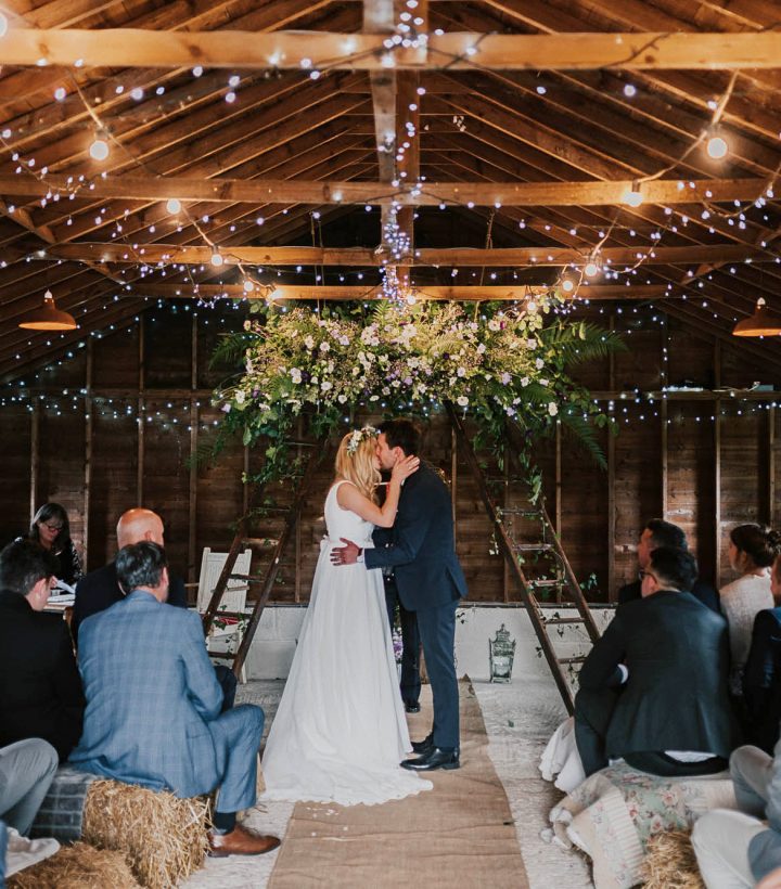 Victoria and Stevie exchanging vows in the rustic barn